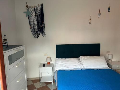 a bedroom with a blue and white bed and a nightstand at il giardino sul mare B&B in Riva Ligure
