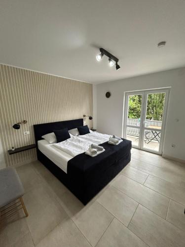 a bedroom with a large bed and a large window at Dom Lovrenko in Mlini