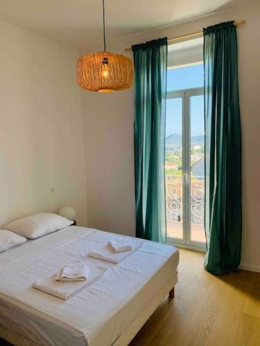 une chambre avec un lit et une grande fenêtre dans l'établissement Grand logement standing centre ville Porto-Vecchio, à Porto-Vecchio