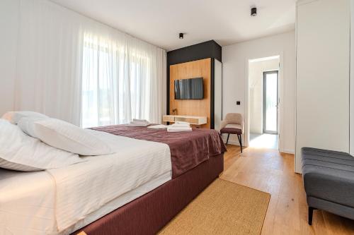 ein Schlafzimmer mit einem großen Bett und einem Stuhl in der Unterkunft Villa Salsola in Zaton