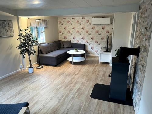 a living room with a couch and a table at Mysigt boende nära Söderåsen in Ljungbyhed