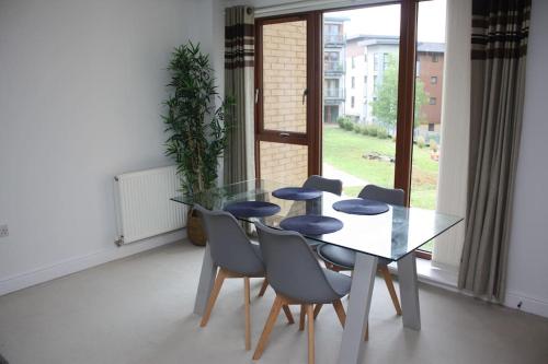 a dining room with a glass table and chairs at Spacious 2 Bed 2 Bath Apartment & Free Parking - LGW 10min drive in Crawley