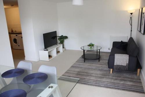 a living room with a couch and a glass table at Spacious 2 Bed 2 Bath Apartment & Free Parking - LGW 10min drive in Crawley