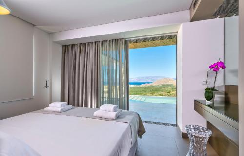a bedroom with a bed and a large window at Youphoria Sea View Villas in Kissamos