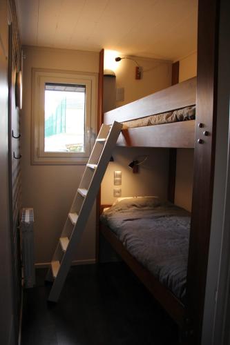 une chambre avec deux lits superposés et une fenêtre dans l'établissement Chaleureux meublé Chessy Proche Disney, à Chessy