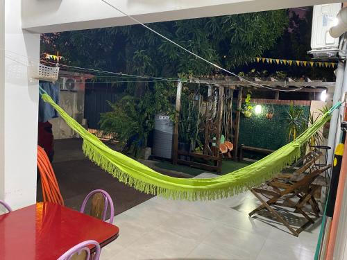 a green hammock in a room with a patio at POSADA DON CANDIDO in San Antonio