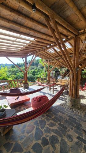 a large wooden building with a hammock in it at Colibamboo the Loft habitación privada con jaccuzi in Pacho