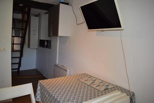 a room with a tv hanging on the wall at Chalet climatisé en bordure de rivière mansardée in Trébas