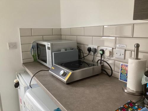 a microwave oven sitting on a counter in a kitchen at Storws Y Gorlan Shepherd's Hut in Valley