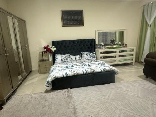 um quarto com uma cama, uma cómoda e um espelho em The Ajman Best Furnished Room em Ajman
