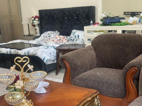 uma sala de estar com duas cadeiras e uma mesa em The Ajman Best Furnished Room em Ajman