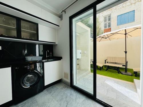 a laundry room with a washer and a sliding glass door at Superbe appartement avec piscine in Tunis
