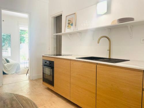 une cuisine avec un évier et une cuisinière dans l'établissement La Maison by Simone, la vrai, à Cannes