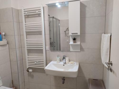 a white bathroom with a sink and a mirror at Apartman Kasic 2 in Konjic
