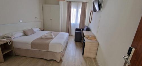 - une petite chambre avec un lit et un bureau dans l'établissement Le Petit Palü Las Palmas, à Las Palmas de Gran Canaria