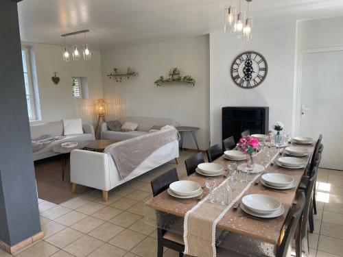 une salle à manger avec une table et un salon dans l'établissement Le Moulin de Mautheville, à Grainville-la-Teinturière