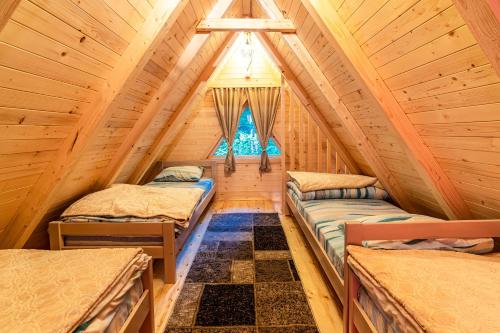 a bedroom with two beds in a log cabin at KOMOVI - Dream house in Ljubaštica