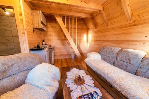 a living room with two couches and a table at KOMOVI - Dream house in Ljubaštica