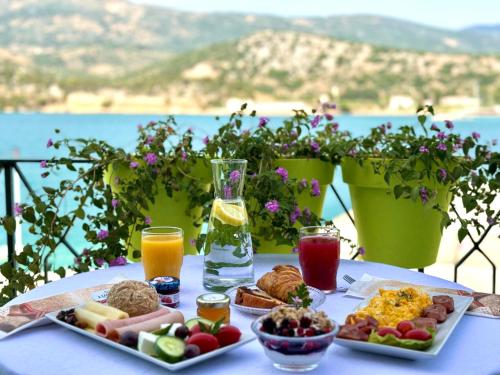una mesa con comida para el desayuno y bebidas en ella en Rouchotas Apartments, en Argostoli