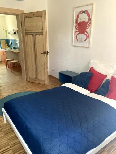 a bedroom with a blue bed with red and blue pillows at Little Fine Apartment close to Leipzig in Zeitz