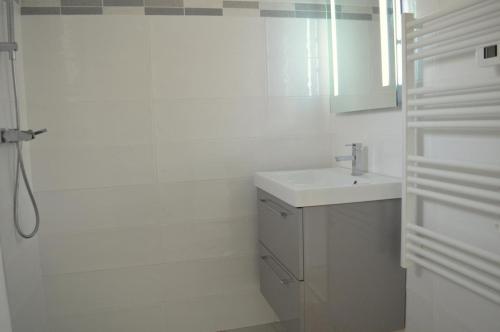 une salle de bain blanche avec un lavabo et une douche dans l'établissement Appart Studio 2 couchages PORT LEUCATE NATURISME PL010-338, à Port-Leucate