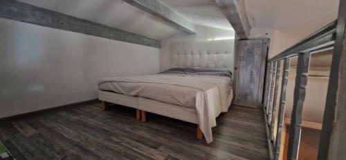 - une petite chambre avec un lit et du parquet dans l'établissement La Maison du Bonheur, à Trans-en-Provence