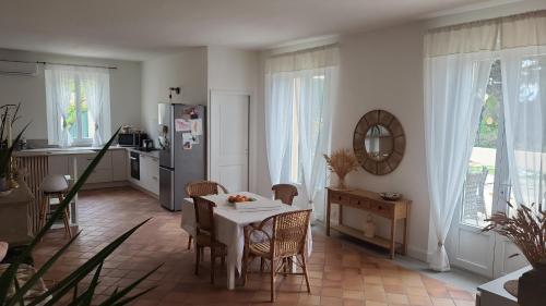 une cuisine avec une table, des chaises et un réfrigérateur dans l'établissement Demeure la Solédad, à Monteux