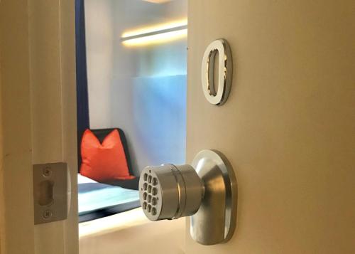 une porte avec un bouton de porte et une chaise rouge dans l'établissement Modern GuestHouse Ironbound Newark with KITCHEN-FastTrainToNYC-OneStopToAirport, à Newark