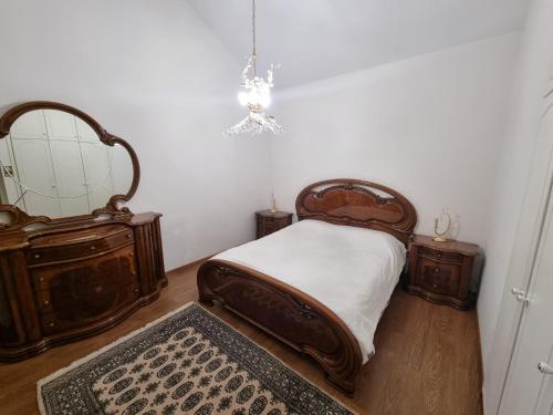 a bedroom with a bed with wooden furniture and a mirror at Salty Sunset Holiday Home in Limassol