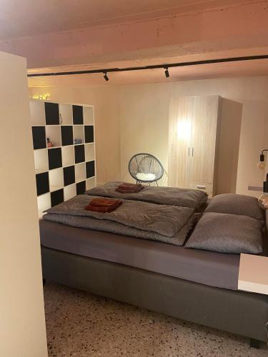 a large bed in a room with a checkered wall at Guesthouse Sprinysem in Zedelgem