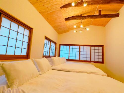 姫路市にあるWholeHouse Himeji ホールハウス 姫路のベッドが2つと窓が2つある寝室