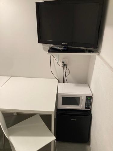 a microwave sitting on top of a table with a tv at Modern GuestHouse Ironbound Newark with KITCHEN-FastTrainToNYC-OneStopToAirport in Newark