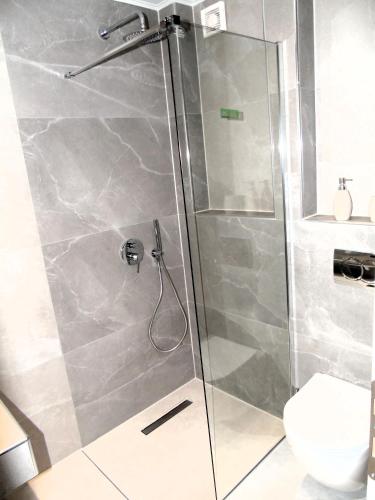 a shower with a glass door in a bathroom at Studios - Nostos in Chrysi Ammoudia