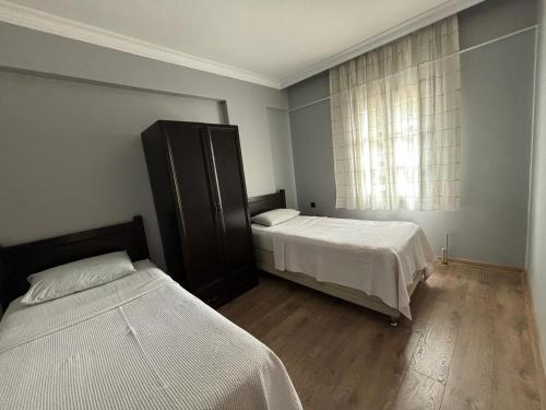 1 dormitorio con 2 camas y ventana en Yalcinkaya Tas Apart en Cesme