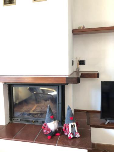 two gnomes are sitting in front of a fireplace at Acero Rosso in Malonno