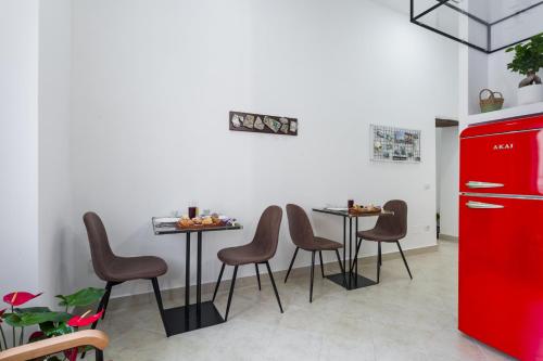 a kitchen with four tables and a red refrigerator at Vesuvio Plaza Room in Ottaviano