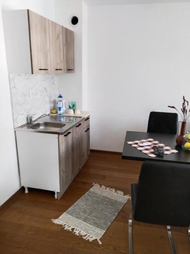a small kitchen with a sink and a table at Sandra apartmani in Vršac