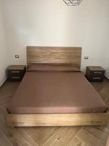 a large bed in a room with two night stands at Casa Marisol in San Giovanni Suèrgiu