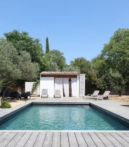 une piscine avec une maison avec une terrasse en bois dans l'établissement 7enGarrigue - Charmant deux pièces avec piscine, à Uzès