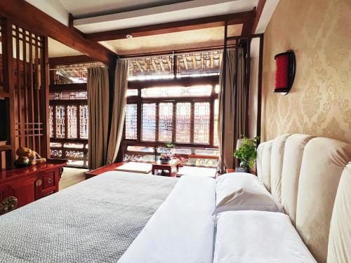 a bedroom with a bed and a large window at 原乡文苑客栈 in Lijiang