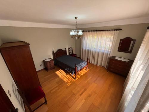 a bedroom with a bed and a wooden floor at Casa dos Neto Santiago in Anadia