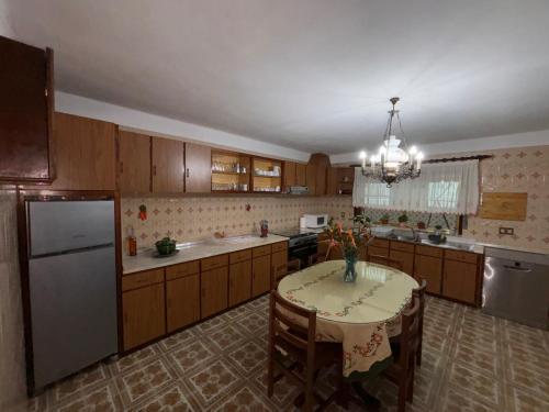 a kitchen with a table and a refrigerator at Casa dos Neto Santiago in Anadia