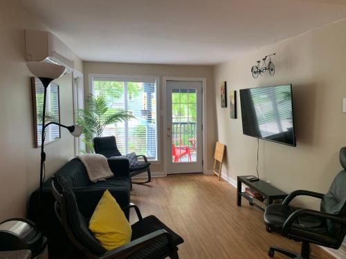 a living room with a couch and chairs and a television at Two bedrooms and large office close to Halifax Citadel in Halifax