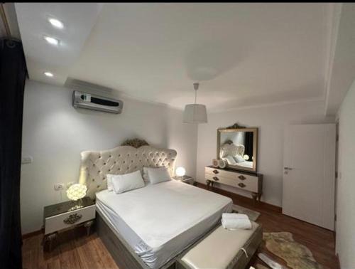 a bedroom with a white bed and a mirror at Luxury apartment smouha in Alexandria