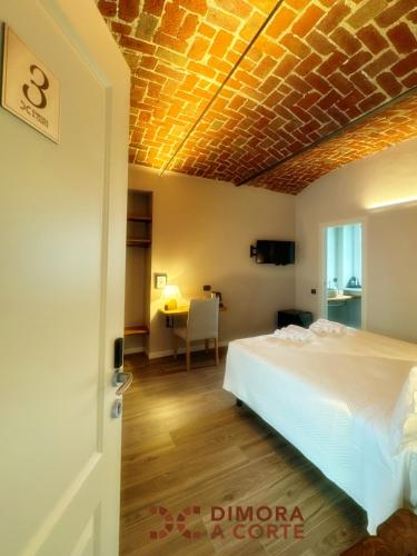 a bedroom with a bed and a table in a room at Dimora a Corte in Mathi