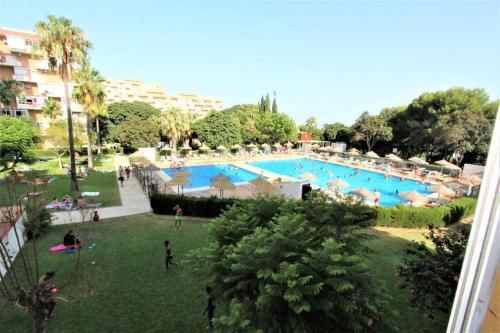 a large swimming pool with people in a park at Agata Apartment Benalmádena in Arroyo de la Miel