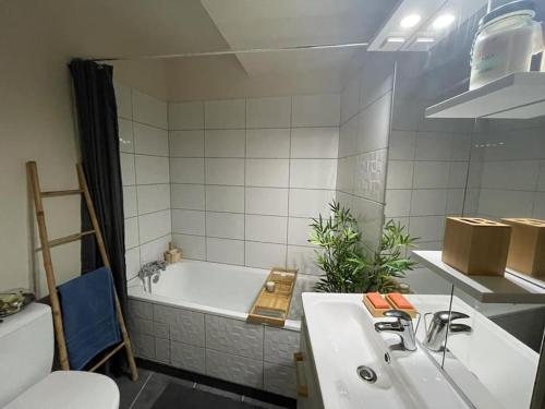 a bathroom with a white tub and a sink at Saint-Girons, charmant studio en plein centre in Saint-Girons