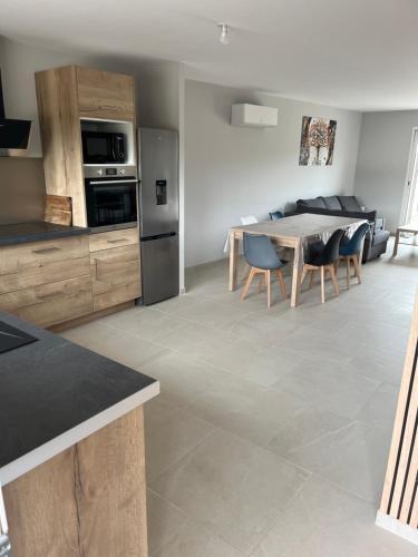 une cuisine et une salle à manger avec une table et des chaises dans l'établissement Maison individuelle, à Authume