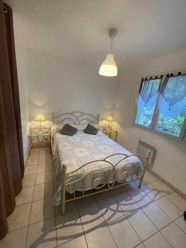 - une chambre avec un lit et deux lampes sur deux tables dans l'établissement Gîtes des Campanes, à Saint Alban Auriolles