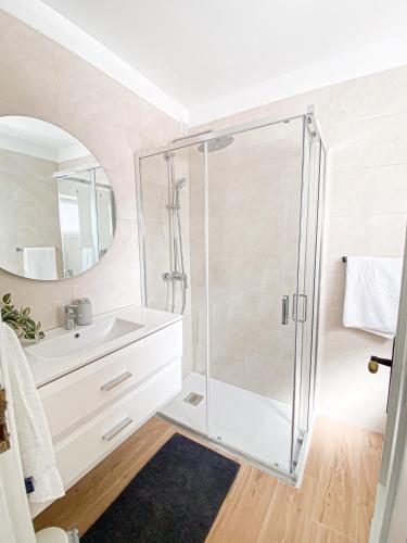 a bathroom with a glass shower and a sink at Casa Joao in Carvoeiro